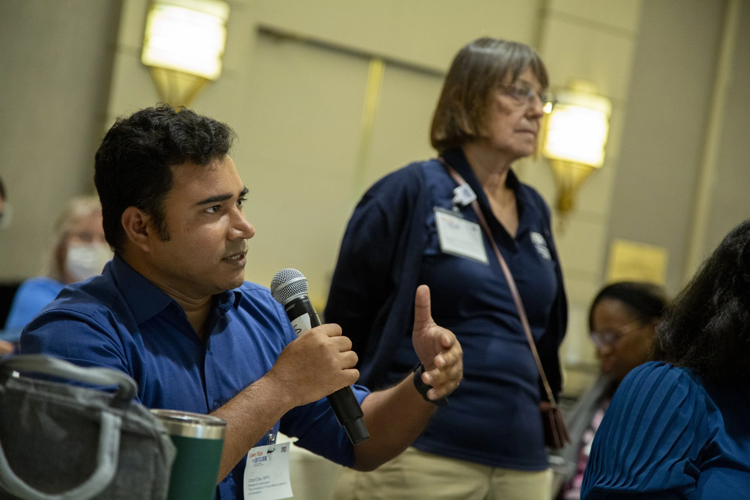 A man with a microphone asks a question at the Texas Public Health Summit 2025.