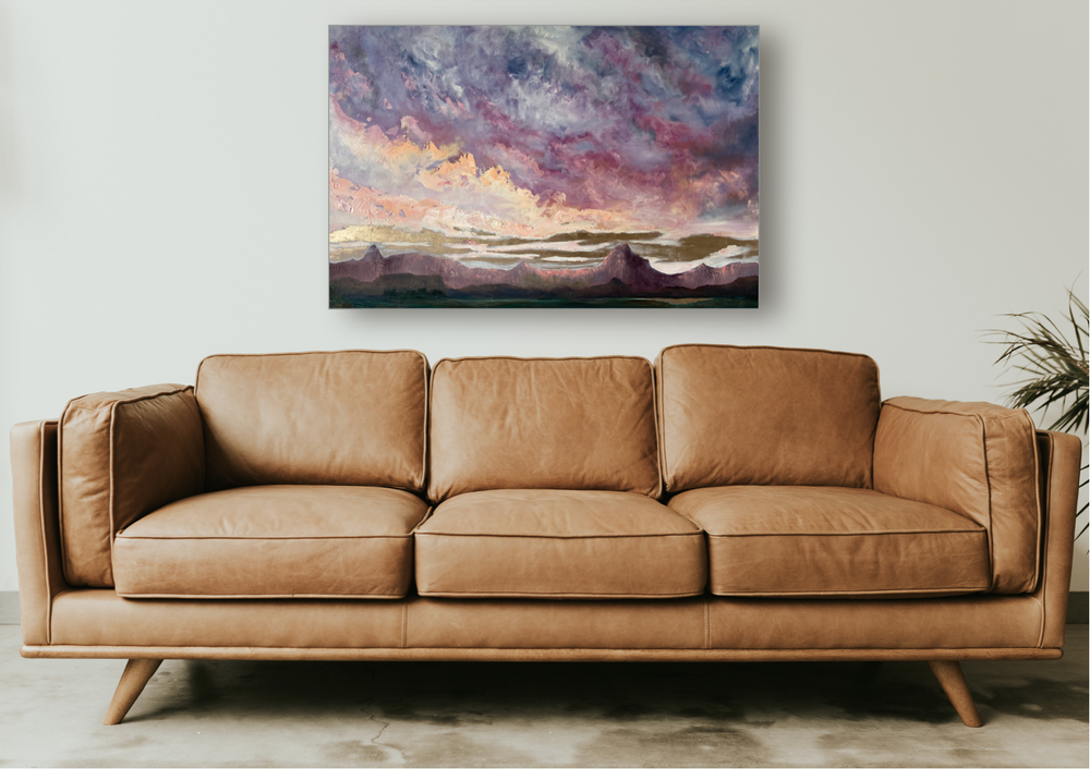 Desert landscape painting above a tan sofa