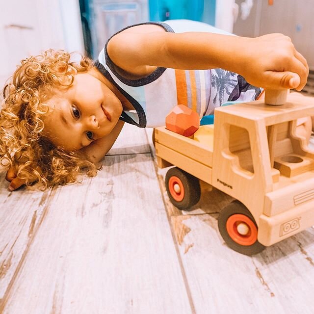 Happily studying the wheels on his truck 🚚 He&rsquo;s always liked playing with this @faguswoodentoys truck, but I think today was the first time he truly made the connection between the controlling the knob on top and the direction of the wheels. H