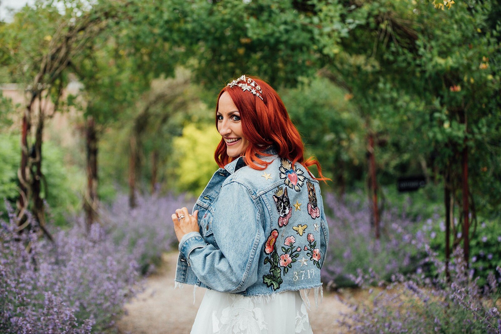 A gorgeous bride with a lace gown, Tilly Thomas Lux jewels and a customised denim jacket | Image by The Twins