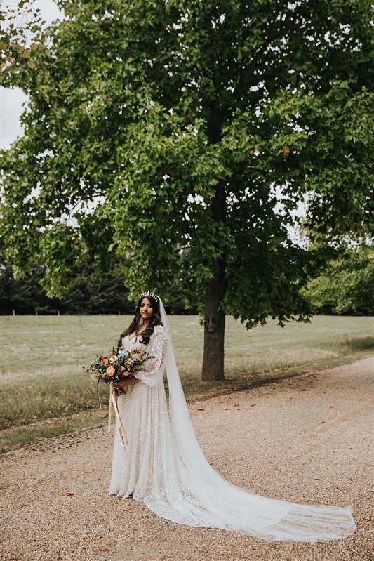 A Tilly Thomas Lux crown and stunning embellished wedding dress with sleeves for a glamorous wedding