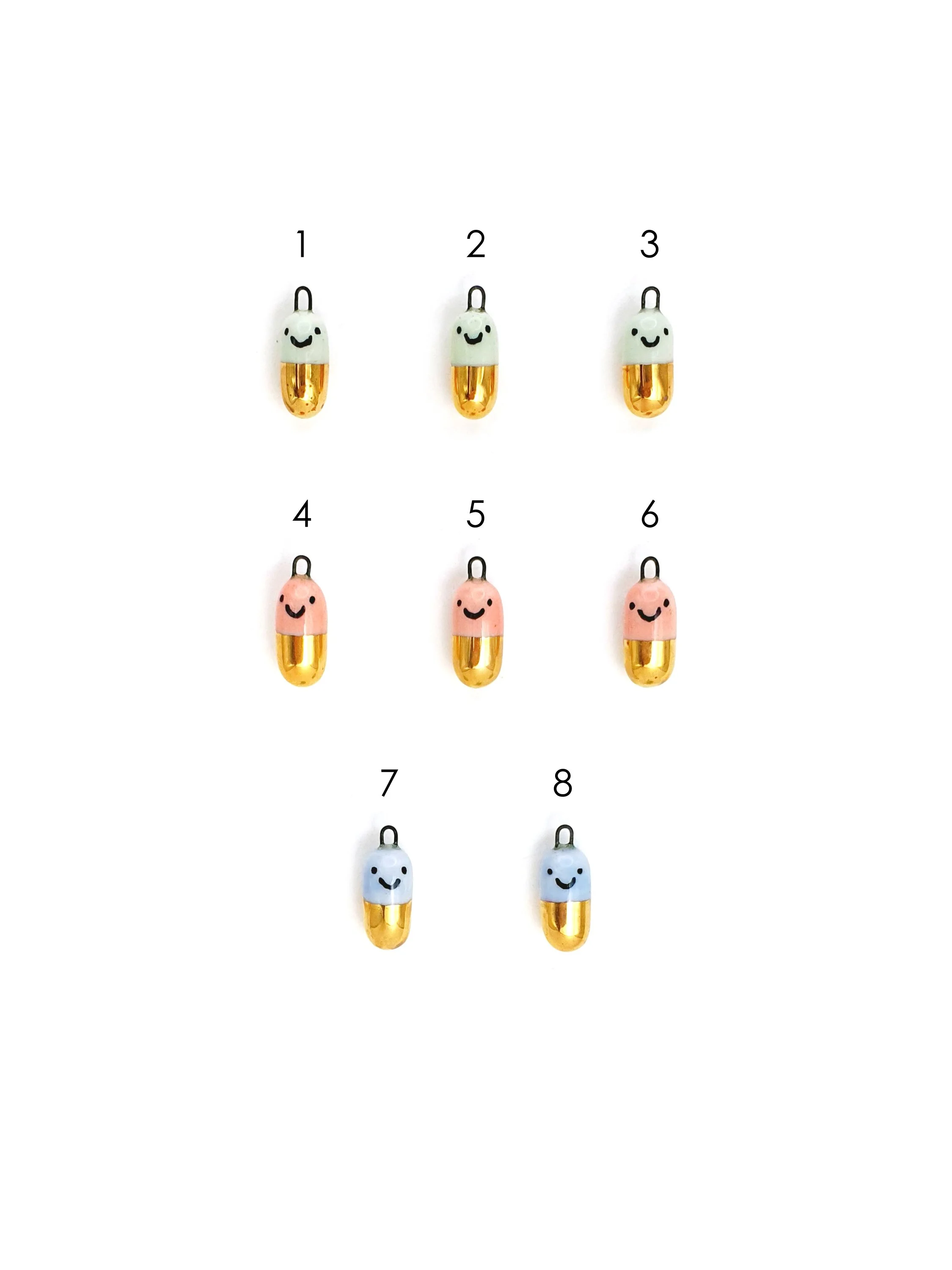 Happy Pill - colour and gold capsule with faces