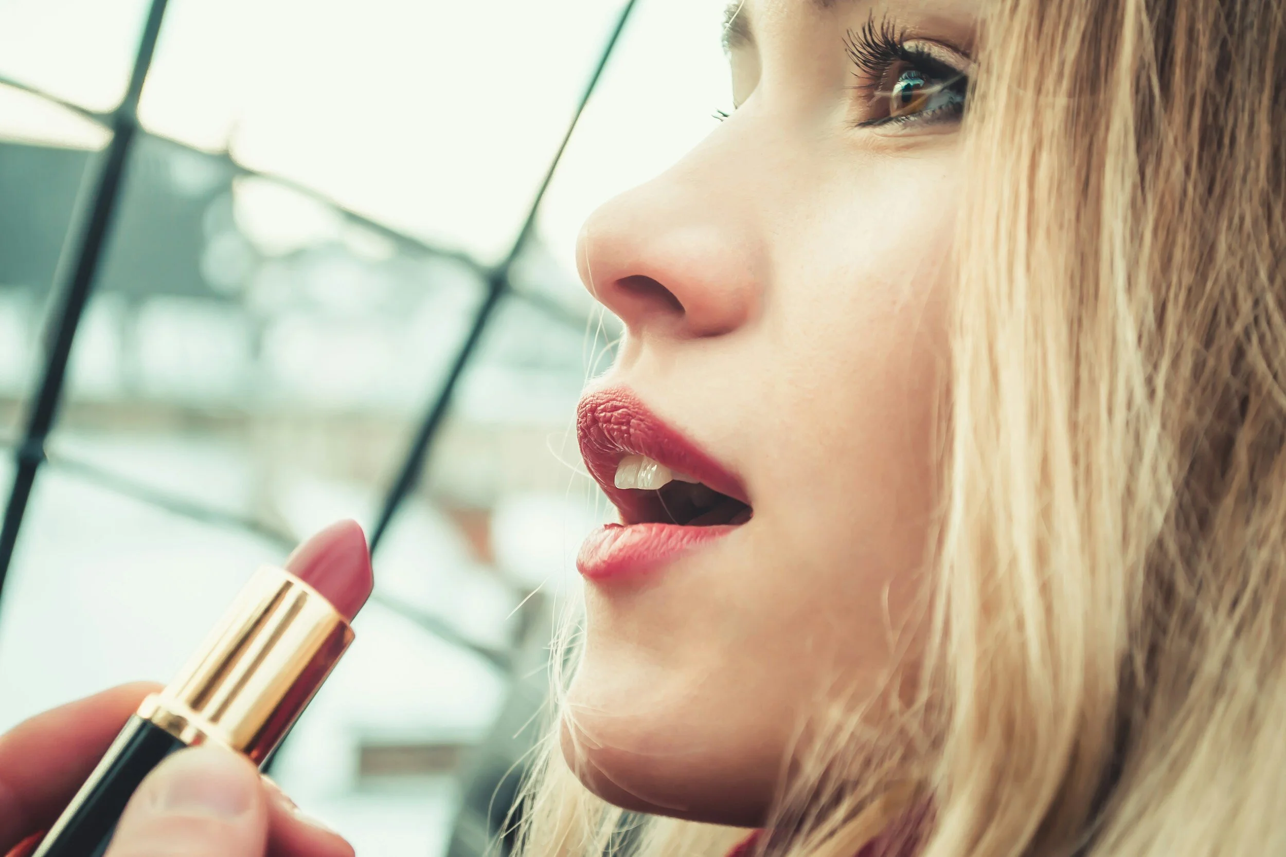 woman having lipstick applied during boudoir photoshoot