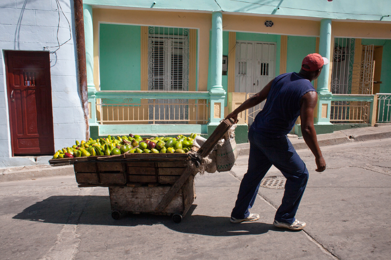  A street vendor pulls a fruit cart up a pedestrian walking street in downtown Santiago de Cuba. 