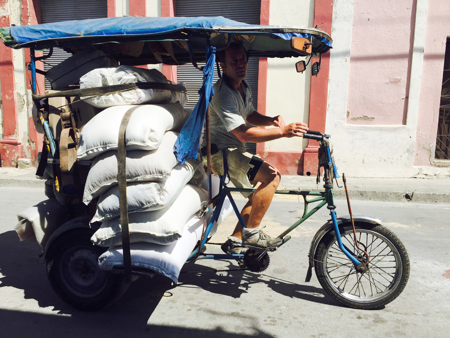  A man transports food rations of rice by bike shipped in from Vietnam for the local people near the port of Santiago de Cuba, Cuba. 