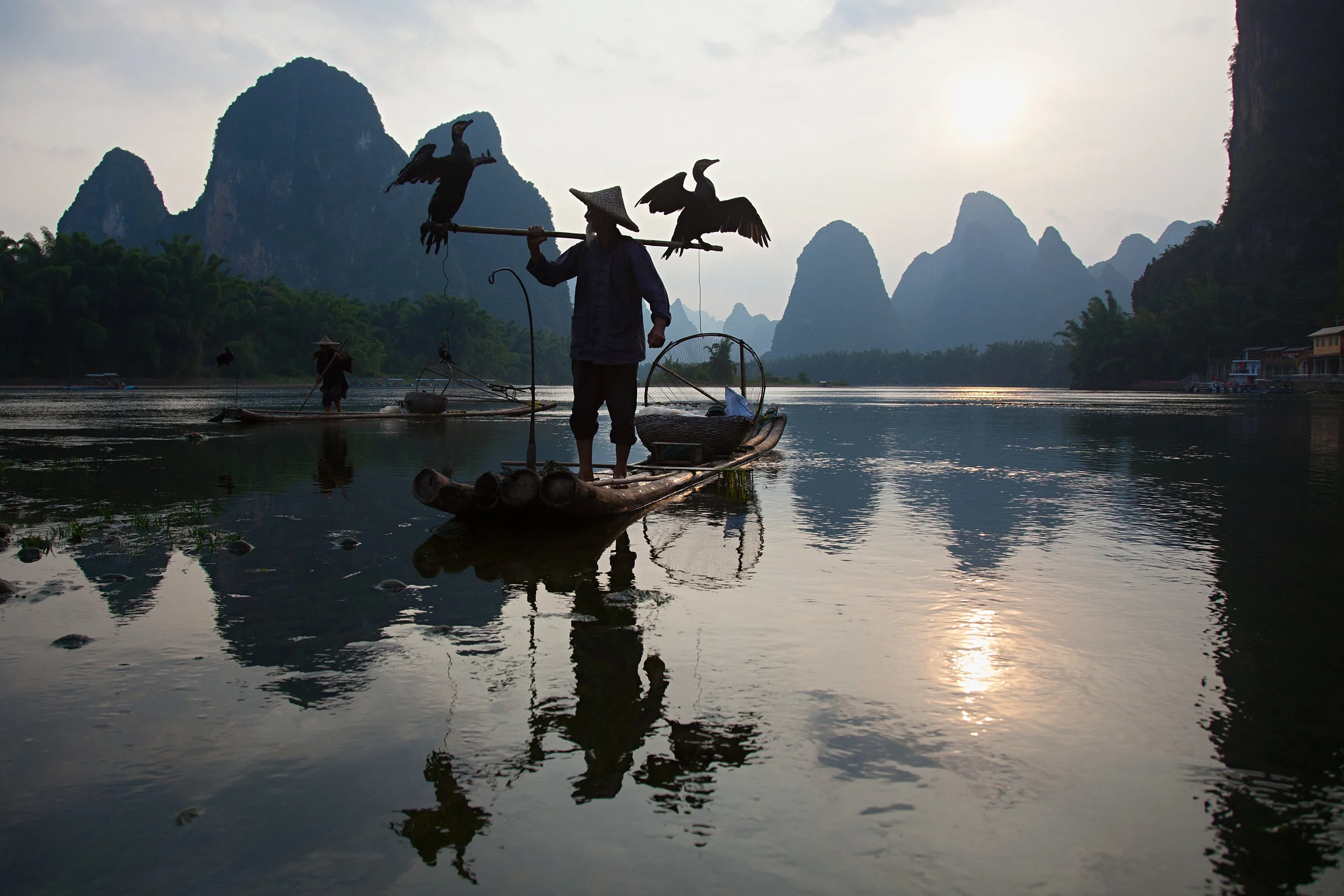   The ancient art of cormorant fishing in China dates back more than a millennium, and is now becoming obsolete due to more efficient techniques, and overfished waterways.    Grandpa Huang, age 80, and his brother, far left, are the oldest fisherman 