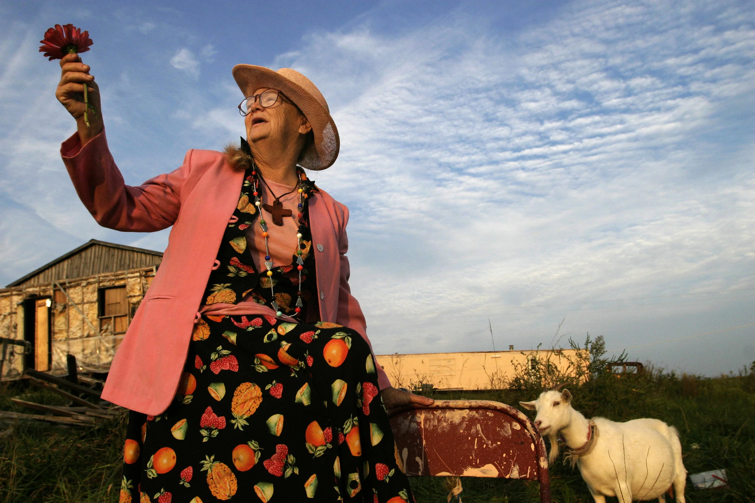 Mary Alice Gordon, who suffers from schizophrenia, motions up to the heavens while sitting with her goat at her homestead in Magnolia, Kentucky.