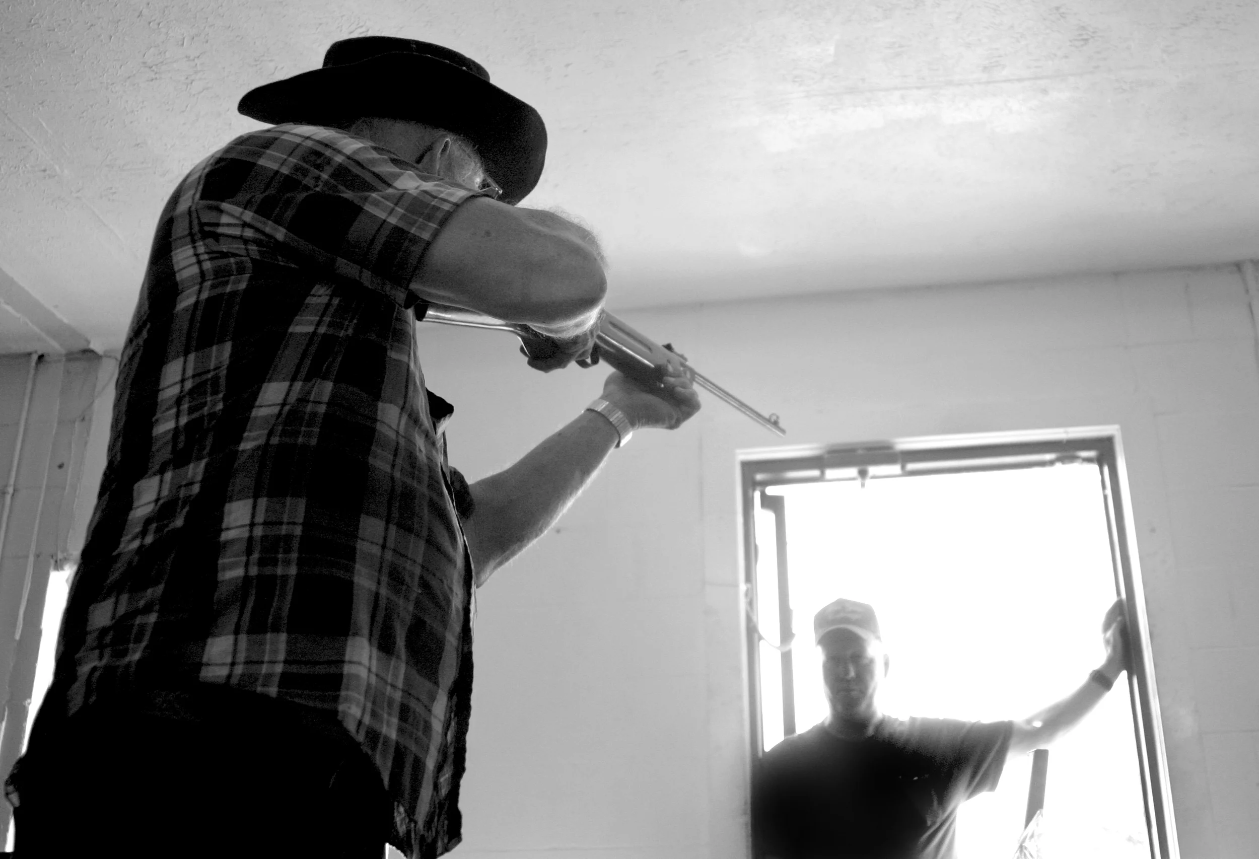 James Kennedy lifts a “for-sale” rifle with shaky hands and aims it at Larry Rust during the weekly auction held every Friday and Sunday in Younger’s Creek, Ky. 