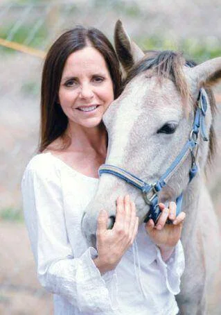 Tina Jo Stephens with Canela, one of their earlier rescue horses at Tina Jo’s Promise.