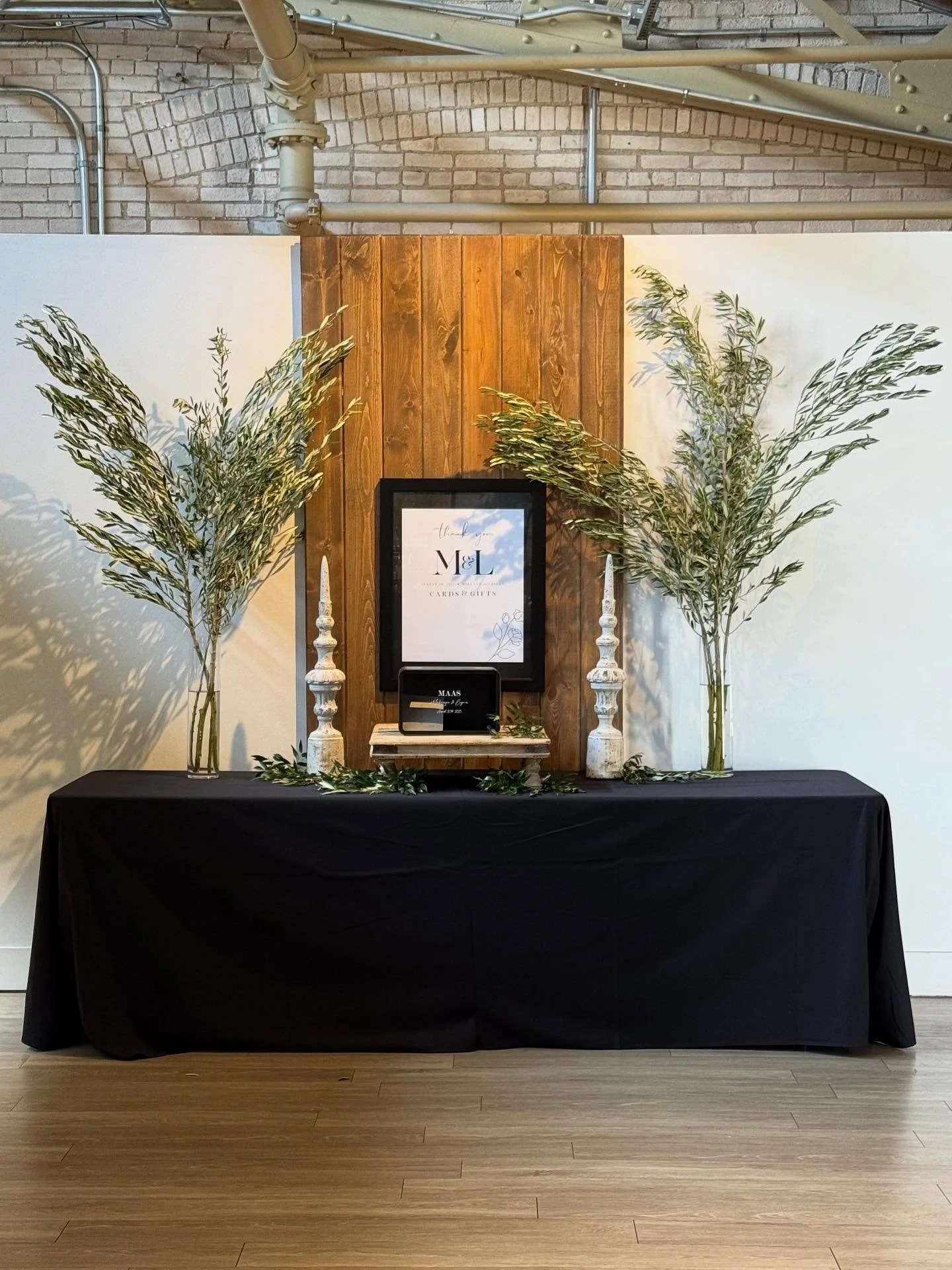 Olive branch added some high drama to this wedding reception at Baker Lofts in Holland, Michigan. Olive was used to design all the tall centerpieces and greenery table runners. Olive branch was also used as an accent in all the floral pieces, includi