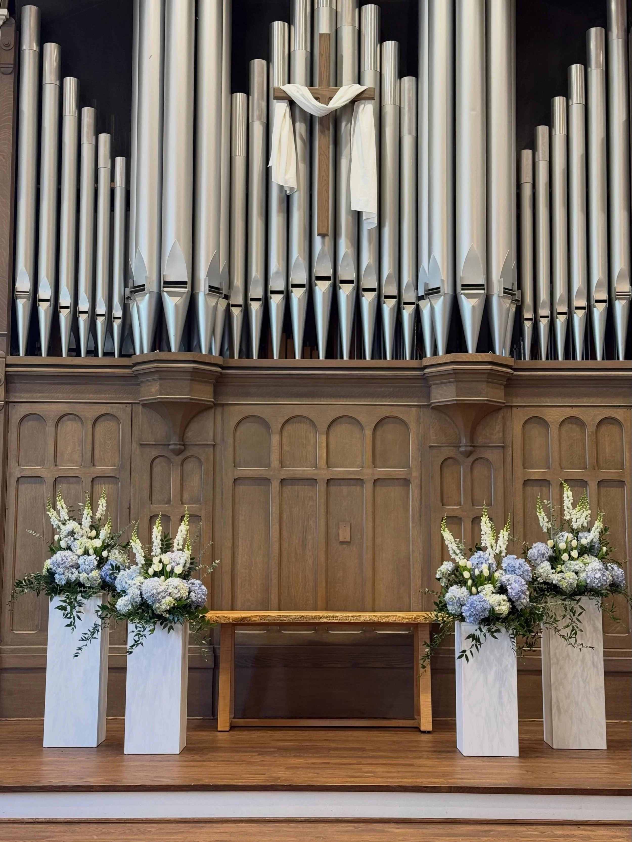 Tulips, snapdragons, and hydrangeas on gallery pedestals for this wedding at Pillar Church in Holland, Michigan