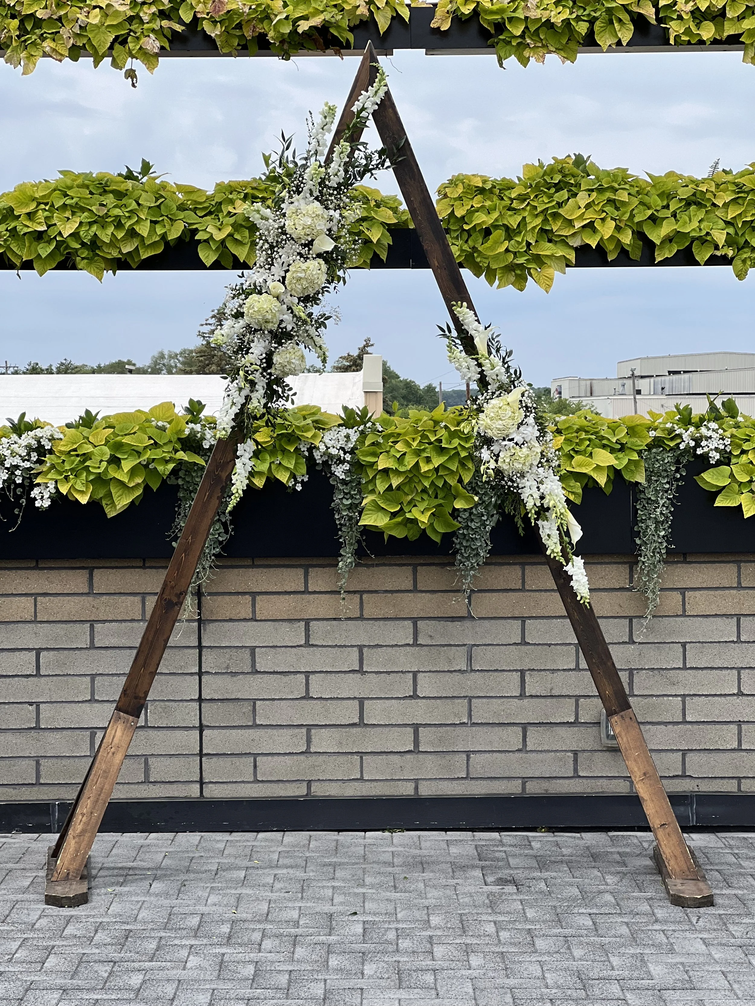 White arrangements on a triangle arch by WS Floral.jpeg