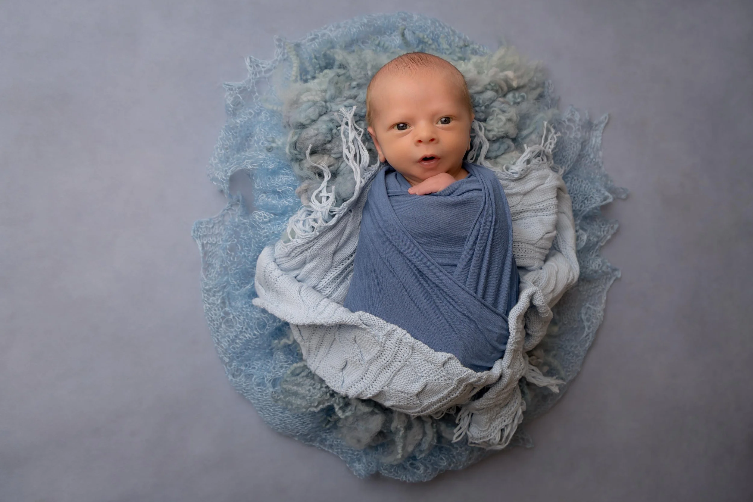 Baby wrapped safely during newborn photography session
