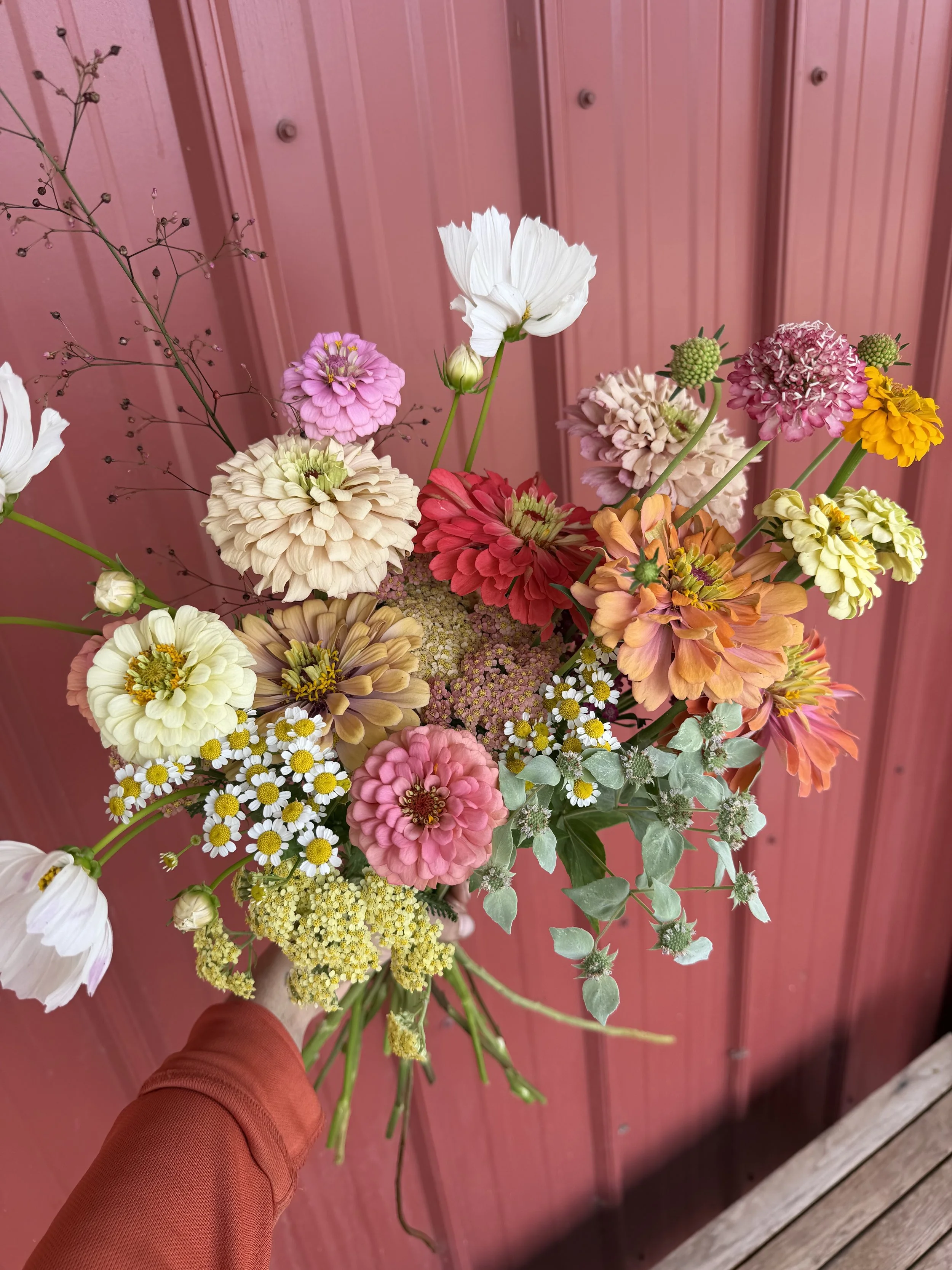 Bouquet filled with summer flowers in various colors of pink, yellow and gold