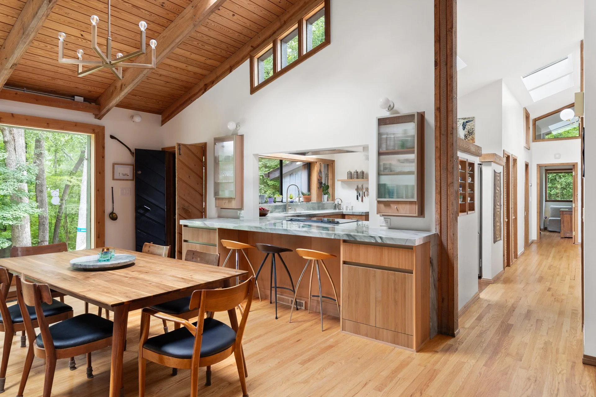 Natural alder wood cabinets in a vaulted great room space with wood ceilings and large windows.