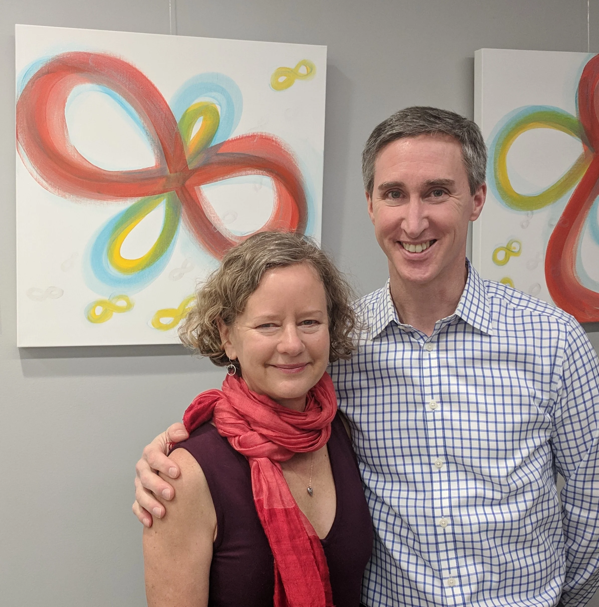 Karin with Dr. Ruff in front of some of her healing art as flying infinities
