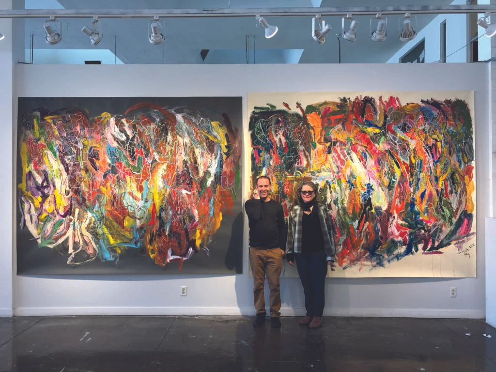 Artist Joseph Alef in front of his paintings with studio instructor Kathleen Henderson.