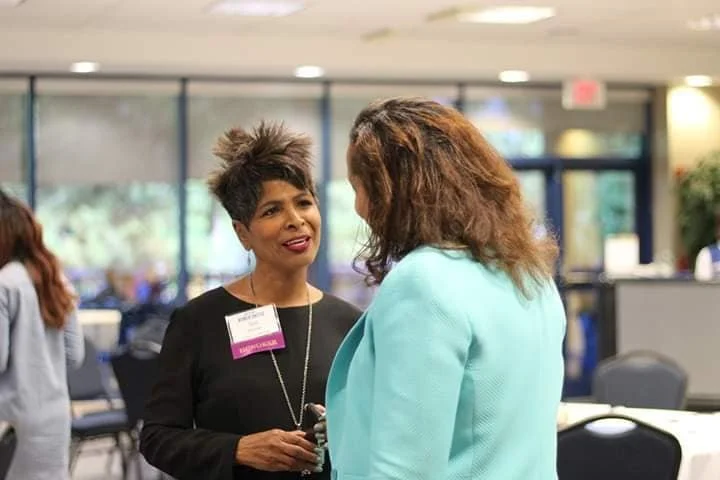 Sol Wynter speaking to a woman inside a meeting hall