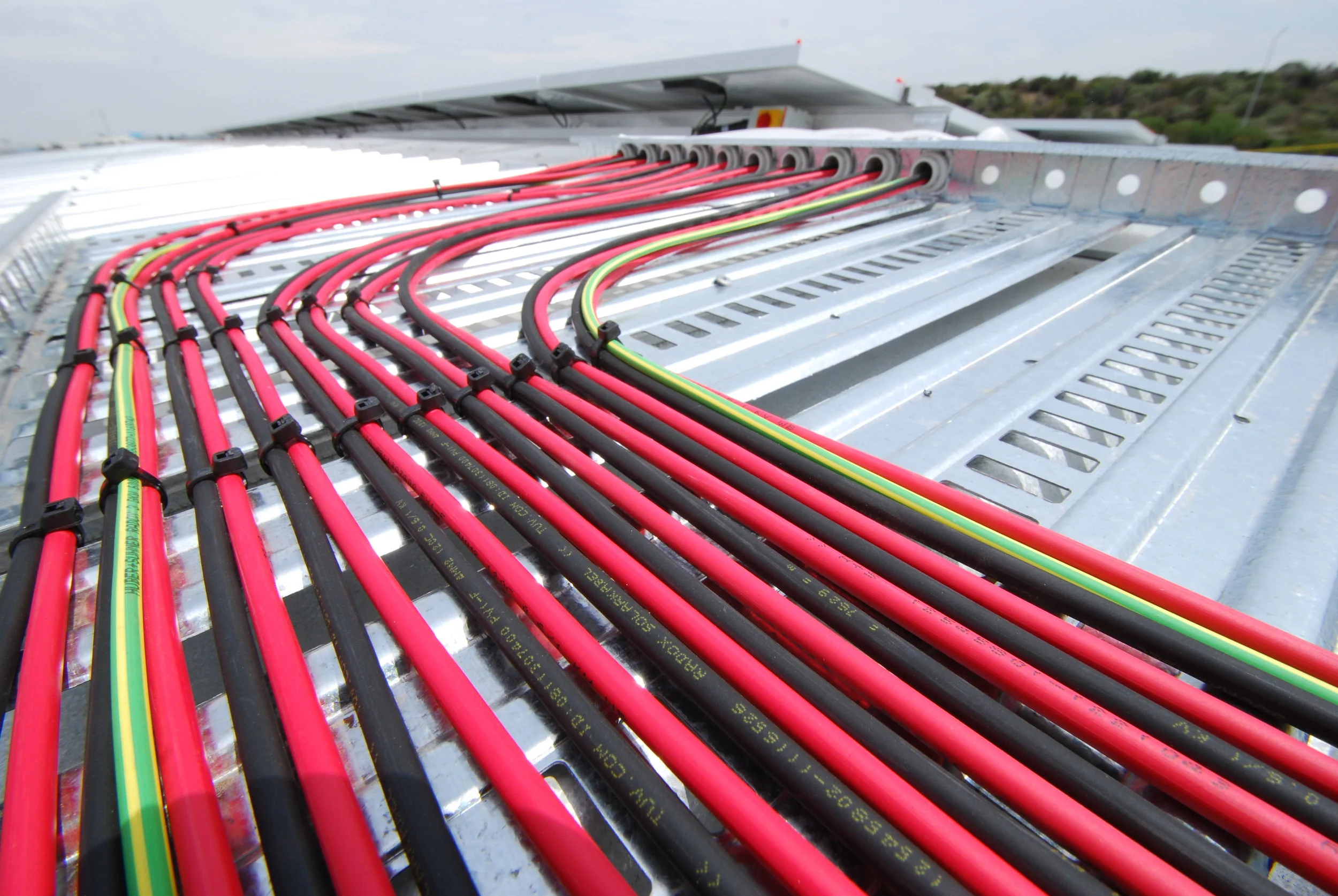 Example: iEnergytech supplies Swiss-made Huber+Suhner DC cable on all its installs. This RADOX cable is fire resistant and has an 8x longer lifetime than XLPE. Its rigid outer structure provides added security during installation work. Photo shows cable work at the 100kWp Holmwood Group installation.