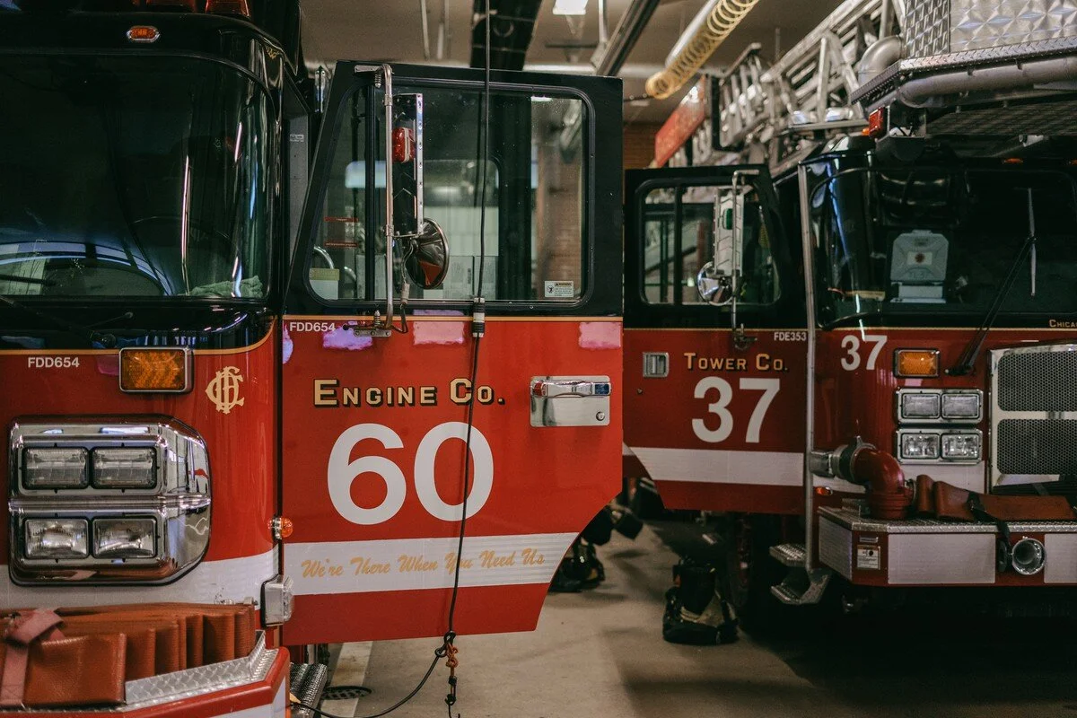  Two fire engines are parked inside of the Hyde Park Fire Station. 
