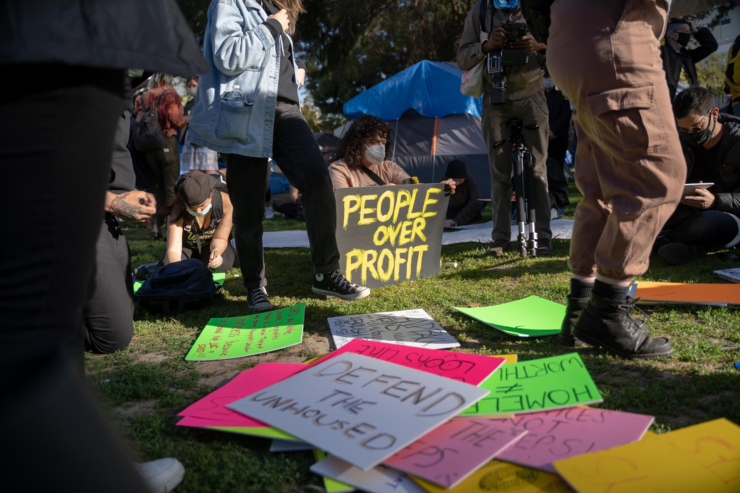 Protesters write on signs at Echo Park Lake.