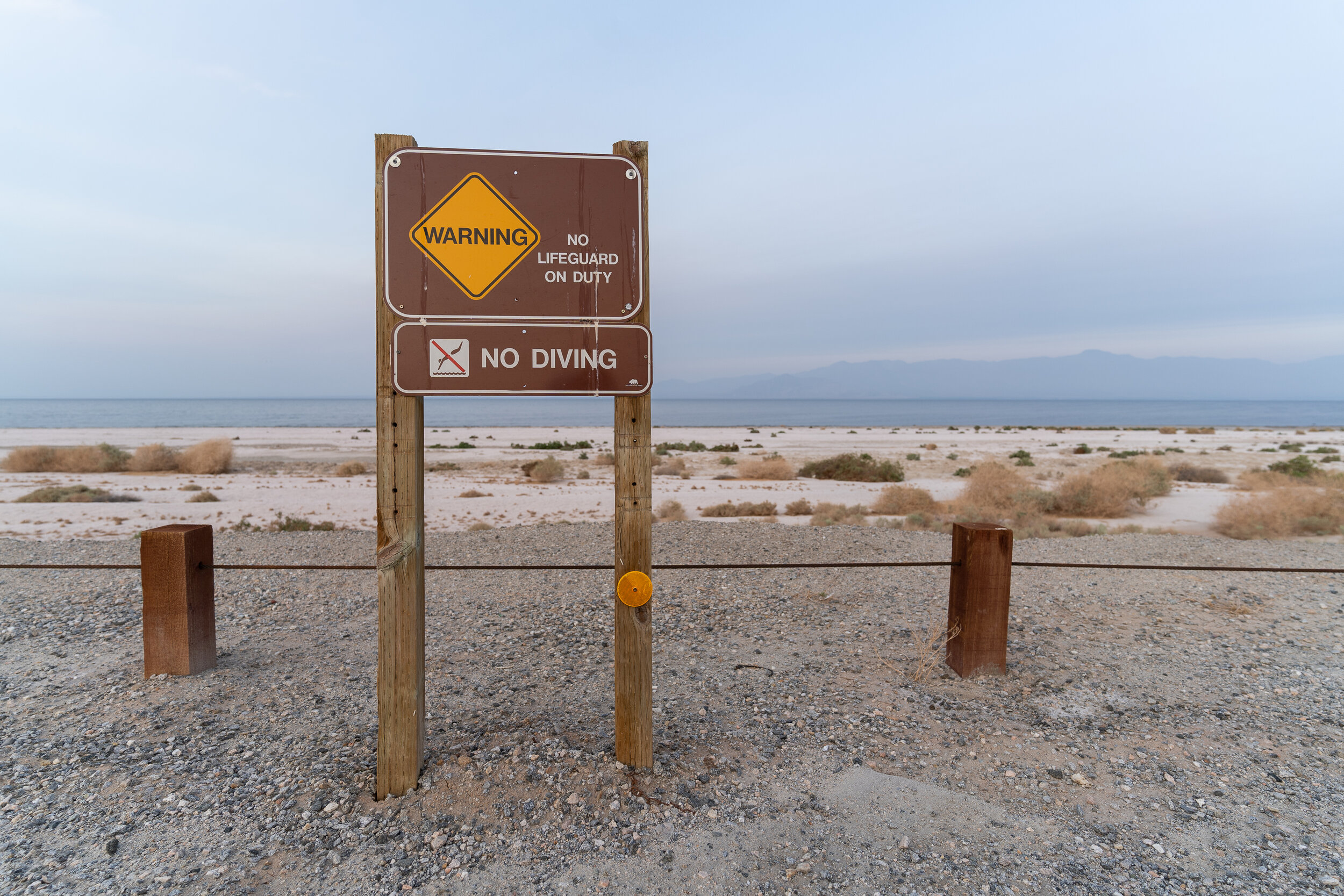 A sign prohibits diving into the Salton Sea, though the shoreline has receded hundreds of feet.