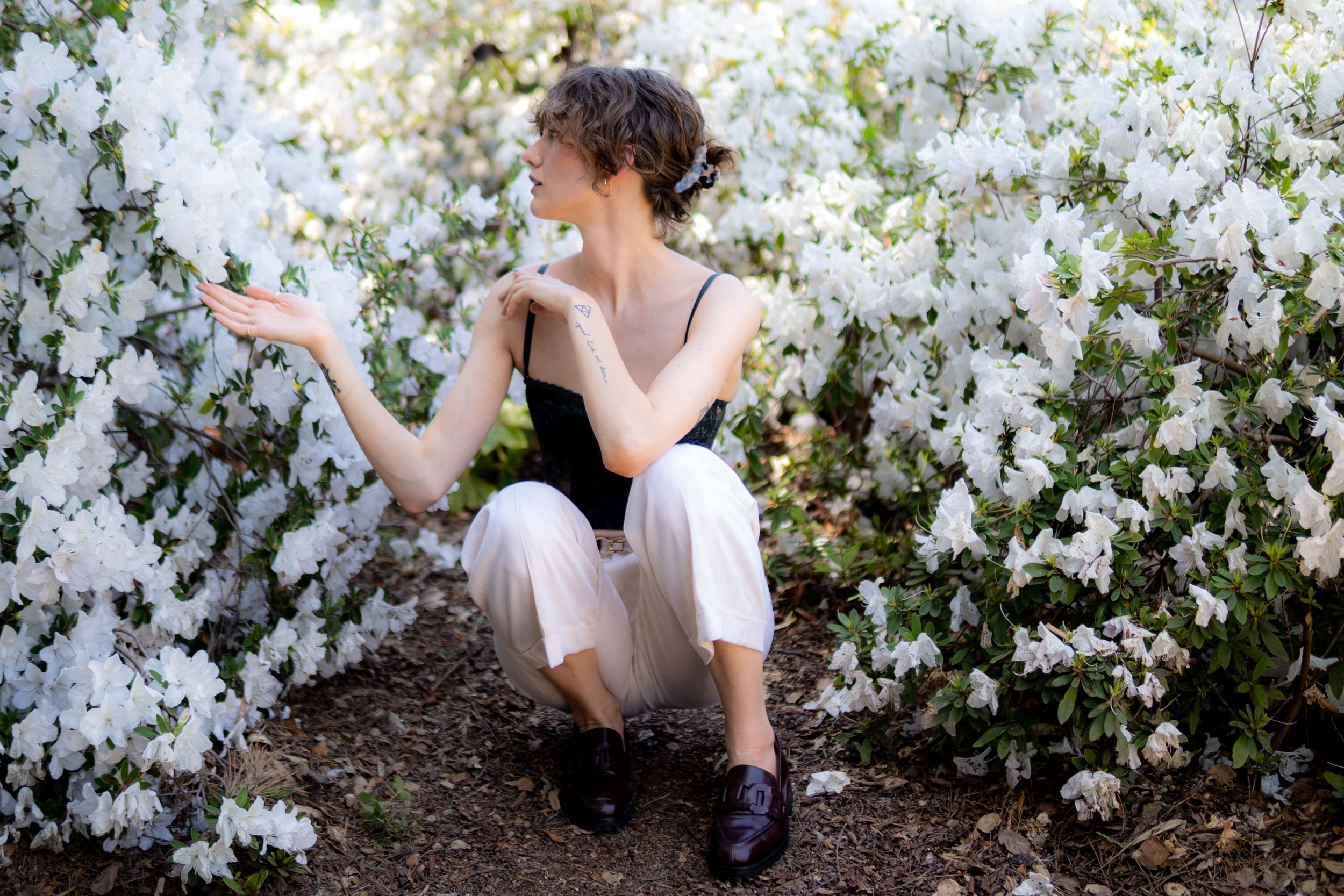 Belle Ives sits among flowers at the Huntington Gardens