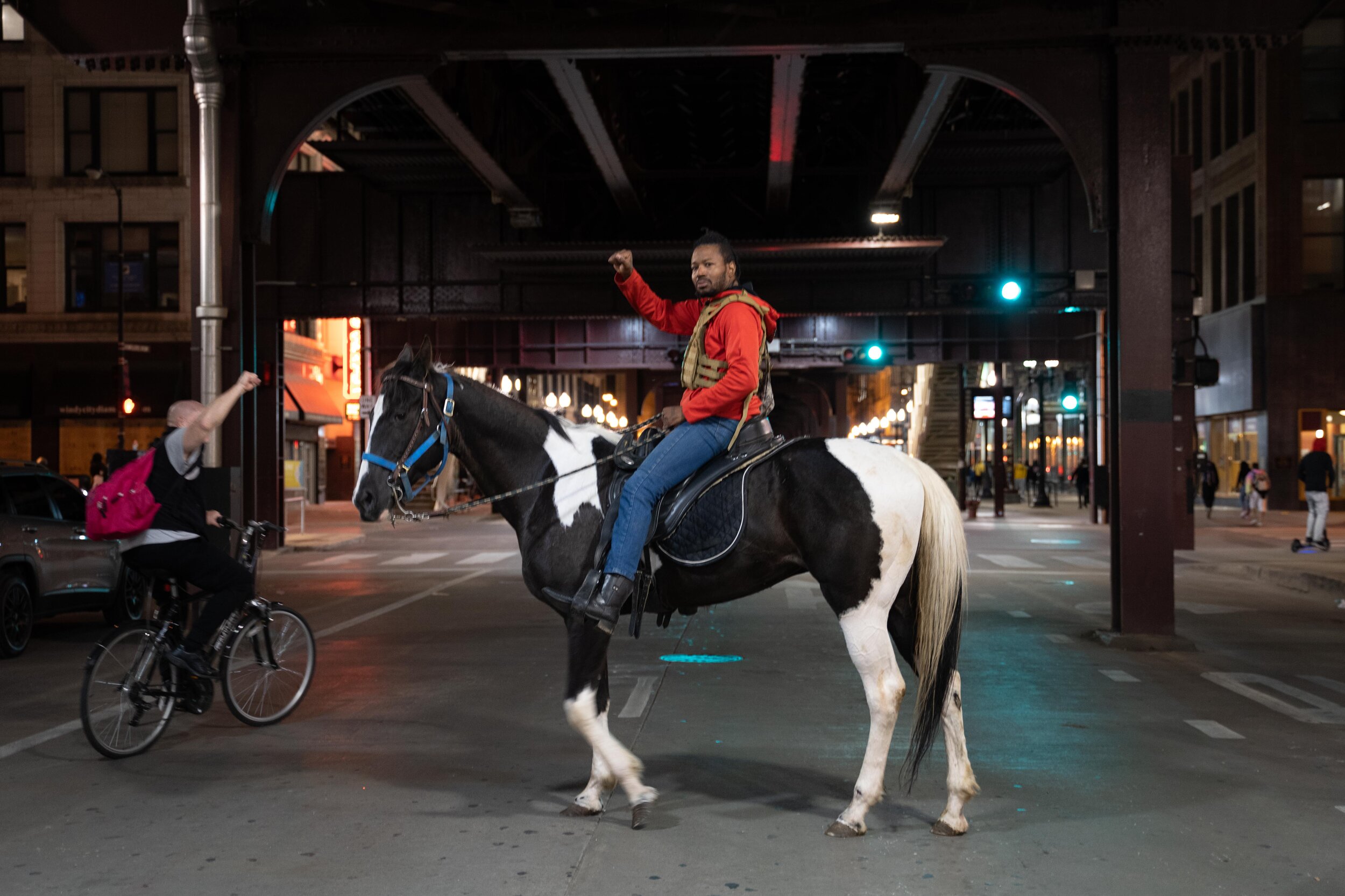 A protester raises his fist as he rides his horse through downtown Chicago.