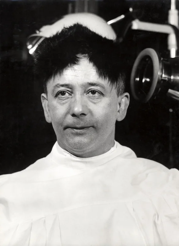 Een wondermiddel tegen kaalheid. Hier een kale man met zogenaamd geïmplanteerd dierlijk haar, 1938. A universal remedy against baldness. A bald man with allegedly implanted animal hair, 1938.