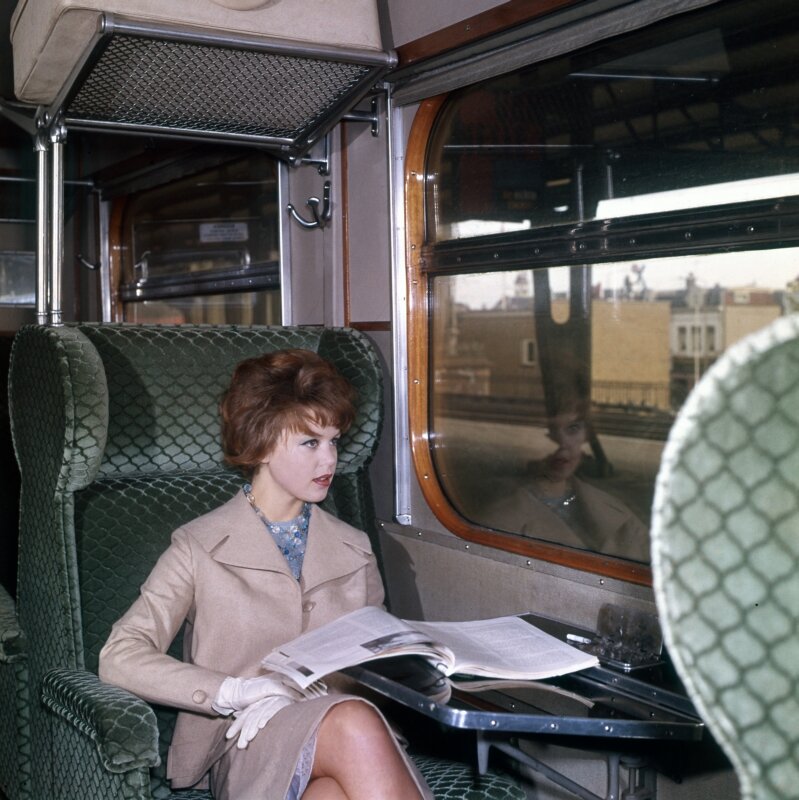  Vrouw zit met een tijdschrift in een trein, de eerste klascoupé, Haarlem, 1961. 