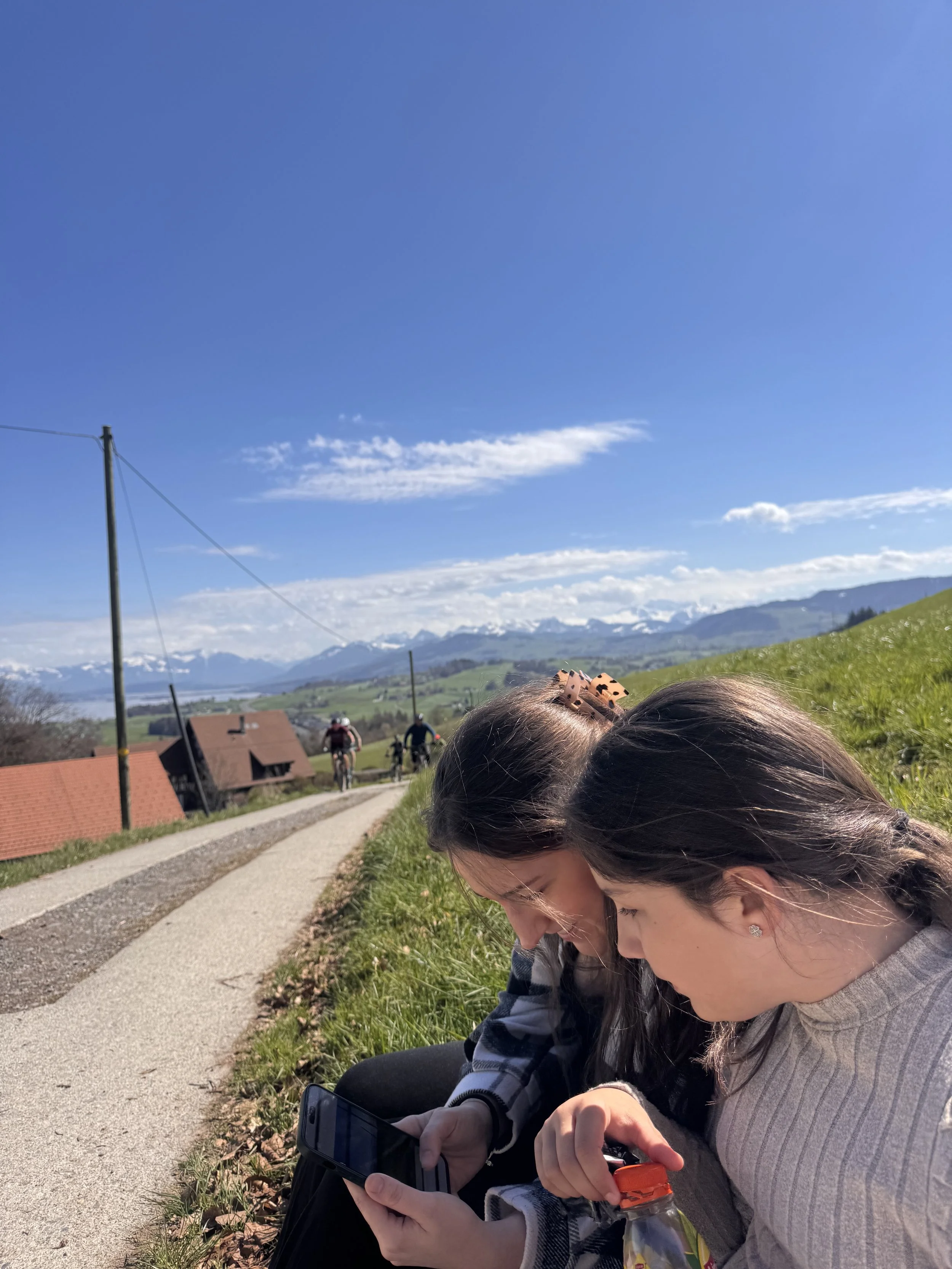 Two people connecting outdoors in a Swiss landscape — representing social connection and relationships as part of The Wellness Coach whole-person approach"
