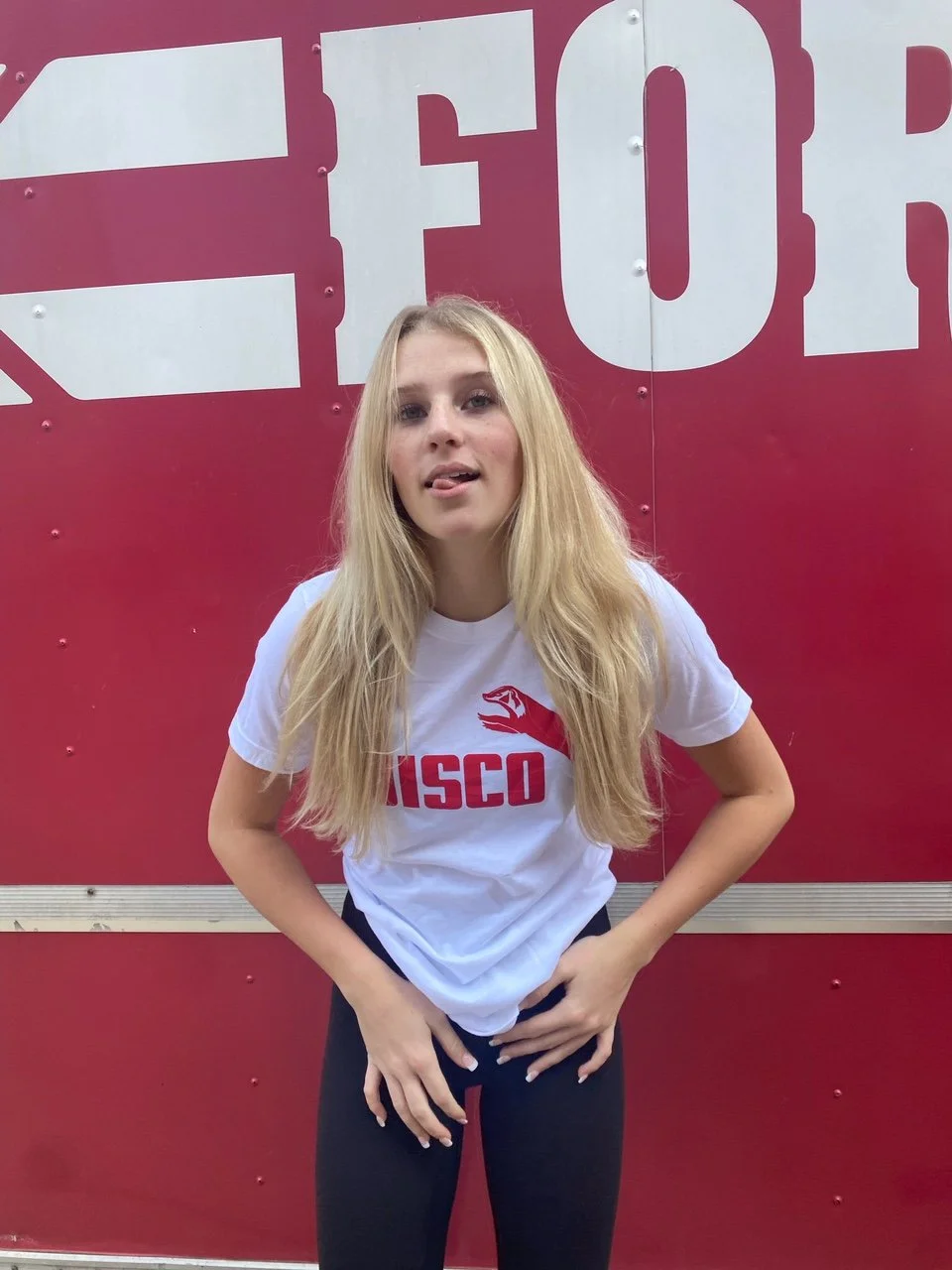 A girl wearing a sueded cotton unisex white tshirt with Wisco INTL screen printed graphic featuring Jumping Badger in the Puma style.