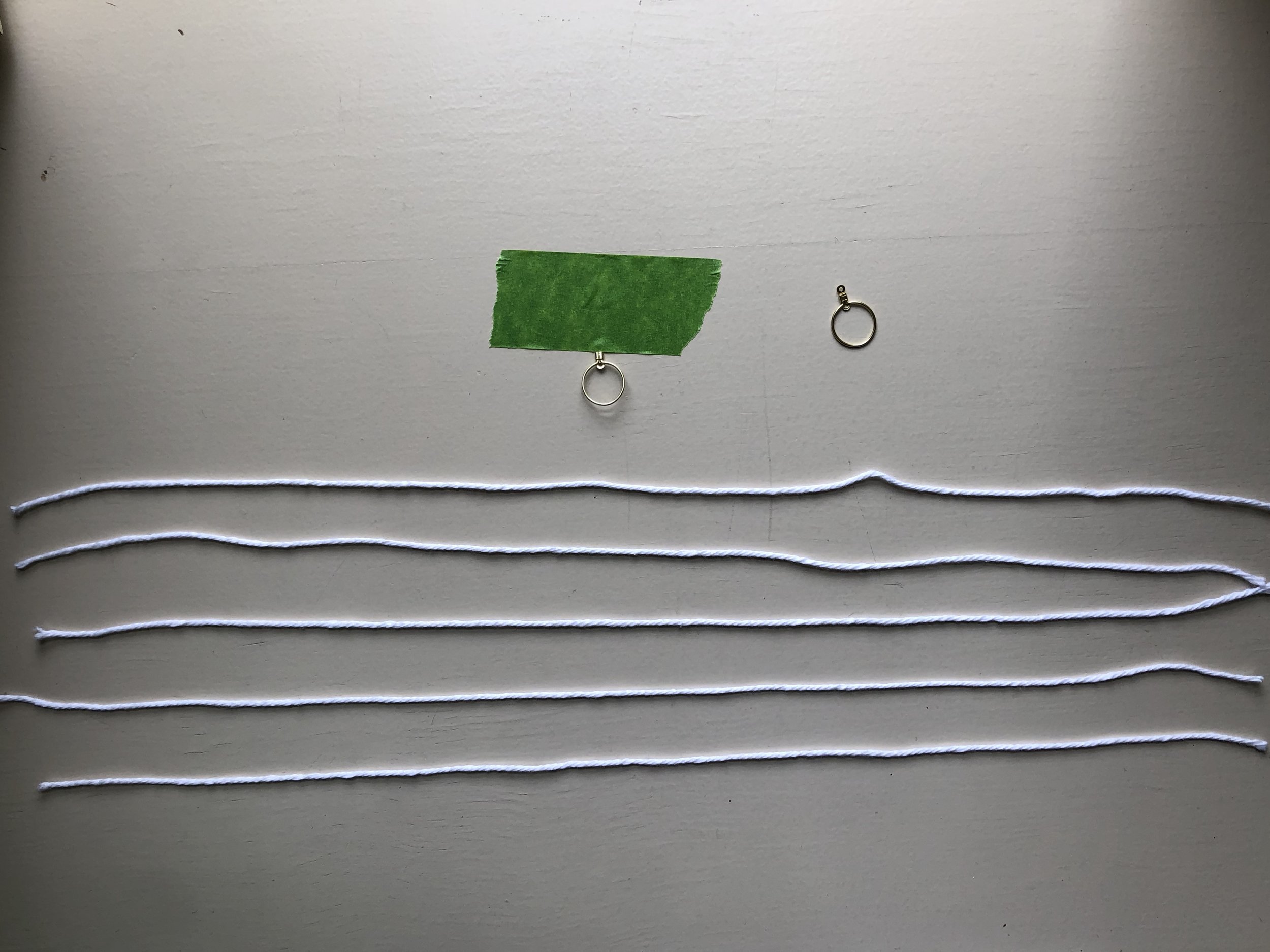 5 pieces of 18” yarn cut with my earring hoop taped down.