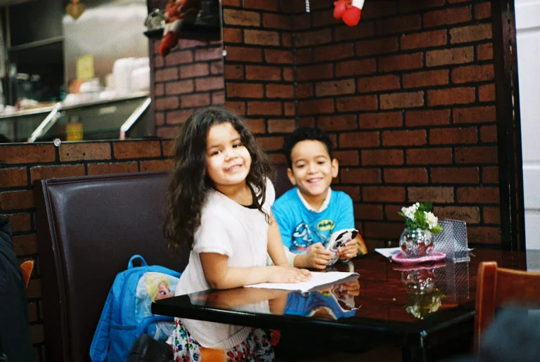 Our new friends laughing when I tried to explain how my “camera” can take pictures without a battery. Sugar Hill, Manhattan. Kodak Ultra Max 400. Pentax K1000. Fletcher Berryman 2019.
