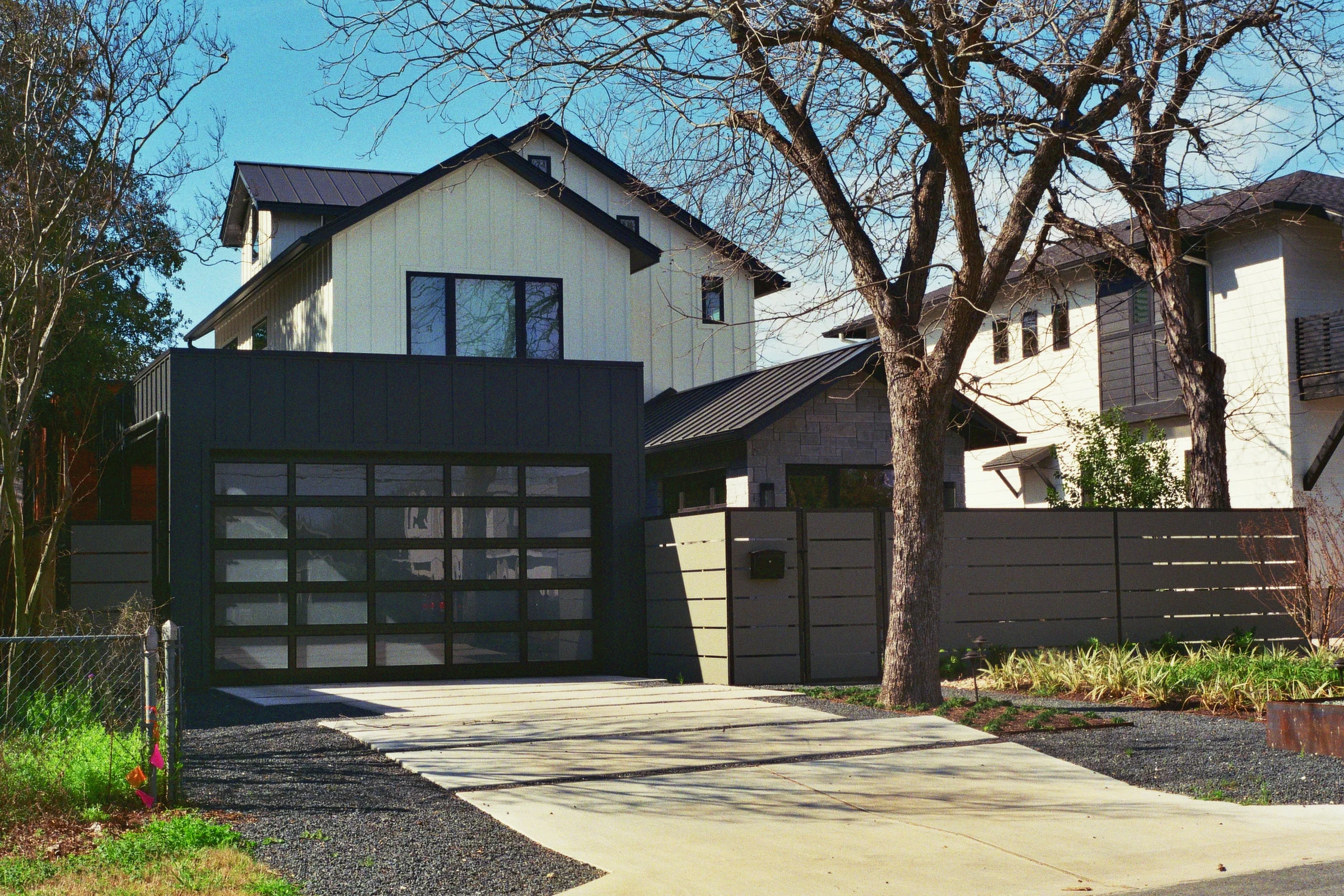 Modern homes stand beside older abodes in a hodgepodge typical of a gentrifying community. Austin, TX Kodak Ultra Max 400. Pentax K1000. Fletcher Berryman 2019.