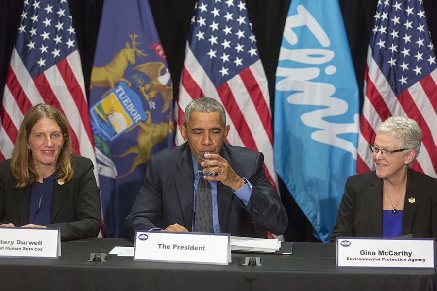 President Barack Obama drinks from a glass of water during a briefing on the Flint public health water crisis during a meeting with federal responders at the Food Bank of Eastern Michigan in Flint, Mich., May 4, 2016. The President is flanked by Hea…