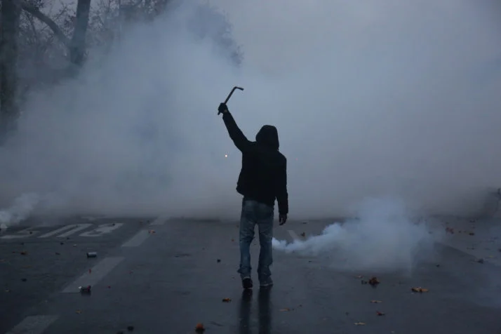 A protester stands surrounded by smoke during a demonstration by Yellow Vests ("gilets jaunes") Paris on December 1, 2018 [Photo: Zakaria Abdelkafi/AFP via Getty Images]