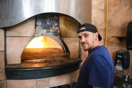 Wade McDonald, owner of King Zah’s Pizzeria in Las Cruces, stands before the wood-fire oven on Thursday, May 14, 2020. [Photo: Nathan Fish / Las Cruces Sun-News]