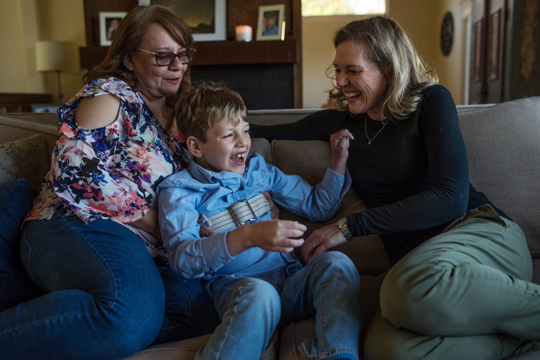 From left: Margarita Sanchez, Ben’s nanny, Ben and Catherine at home. Ben wears a strap to prevent him from falling when he has his seizures. September Dawn Bottoms for The New York Times