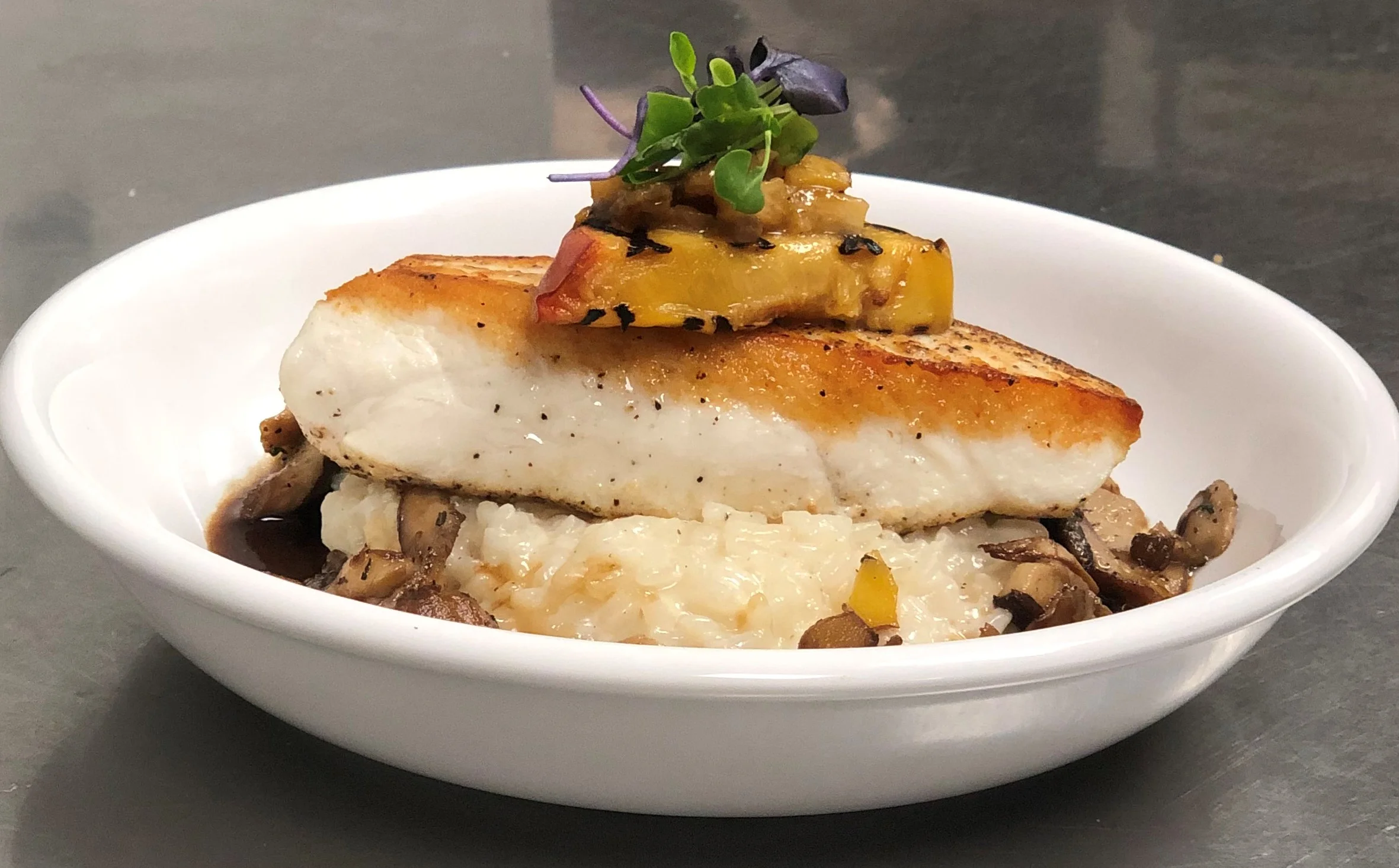 CAFÉ THYME | Local CA halibut with porcini broth, peach chutney, grilled peach, risotto, and mixed micro greens.