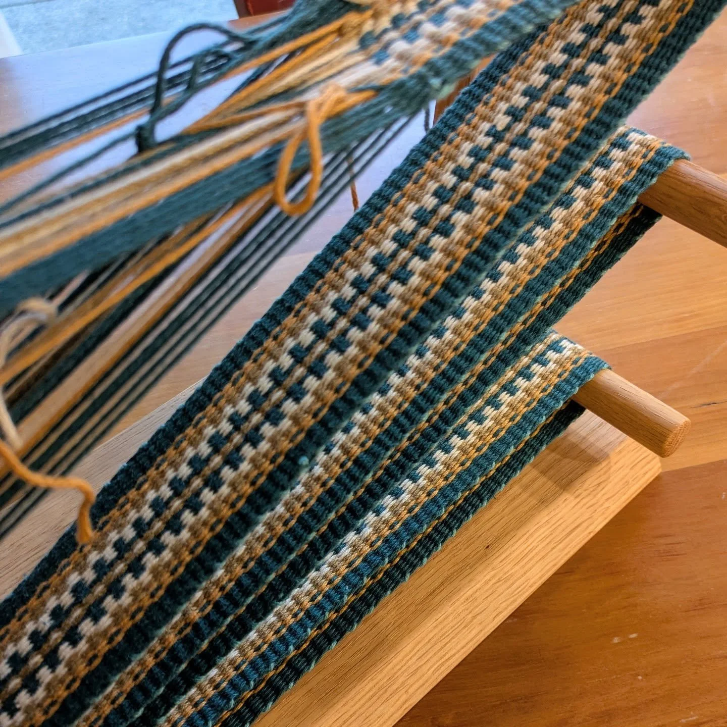 I made some mistakes in warping this and thought I had a disaster on my hands, but I bravely took it apart mid-weave and fixed whatever I did wrong. Instead of a short section of strap and a big pile of tangled yarn, I have this long length of strap 