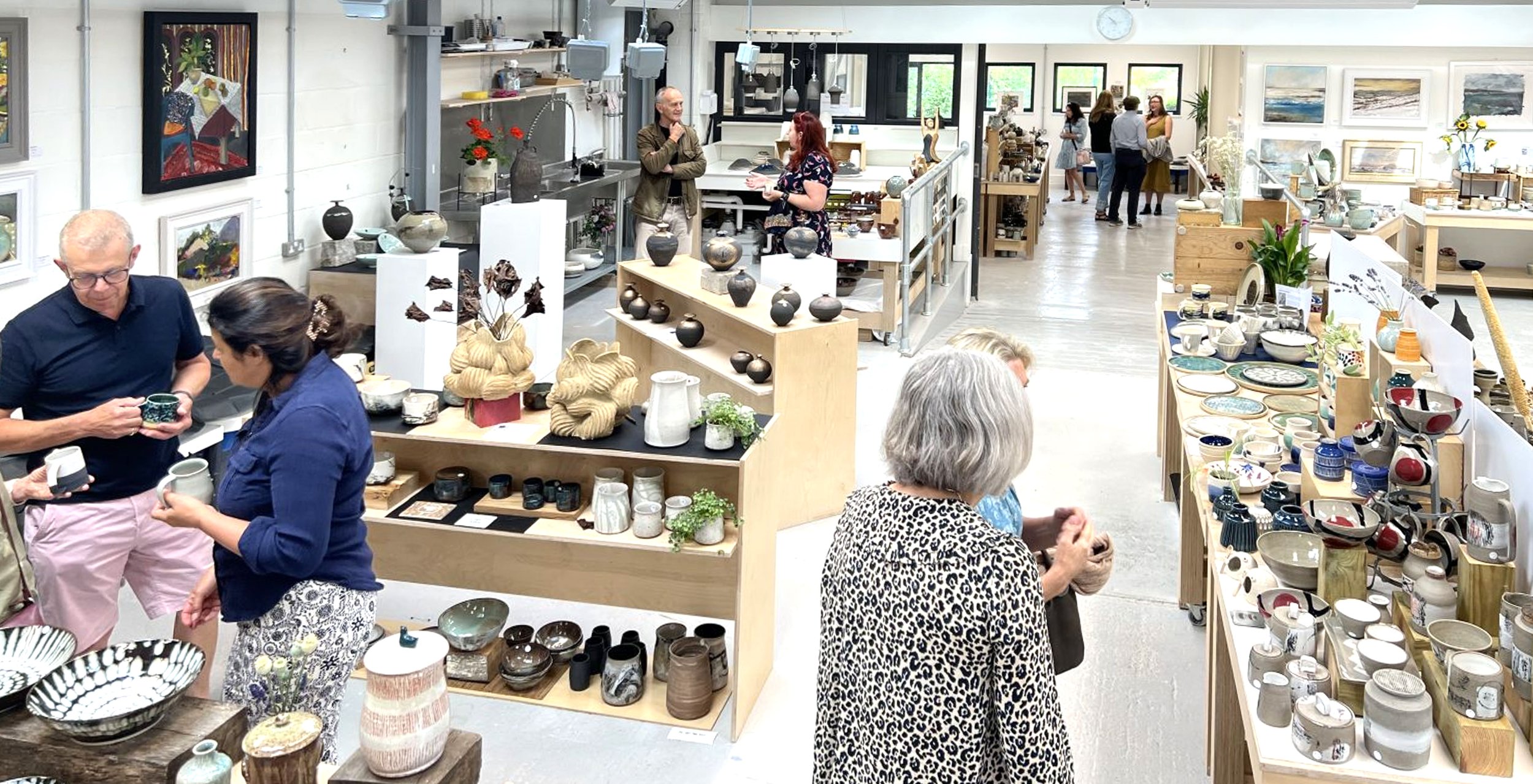 Pottery pieces and people inside Kiln Cambridge's ceramics studio