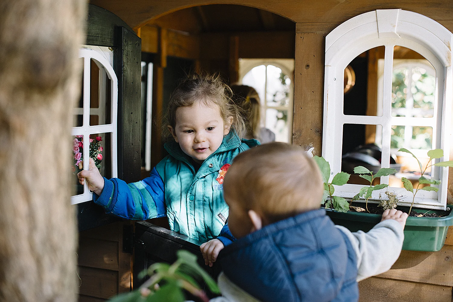 toddlers playing in outdoor playhouse.jpg