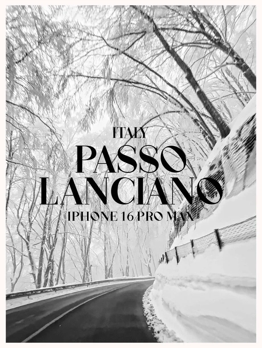 Black and white photograph of a snow-covered road in Italy, surrounded by snow-laden trees. Overlay text reads 'Italy Passo Lanciao iPhone 16 Pro Max'.