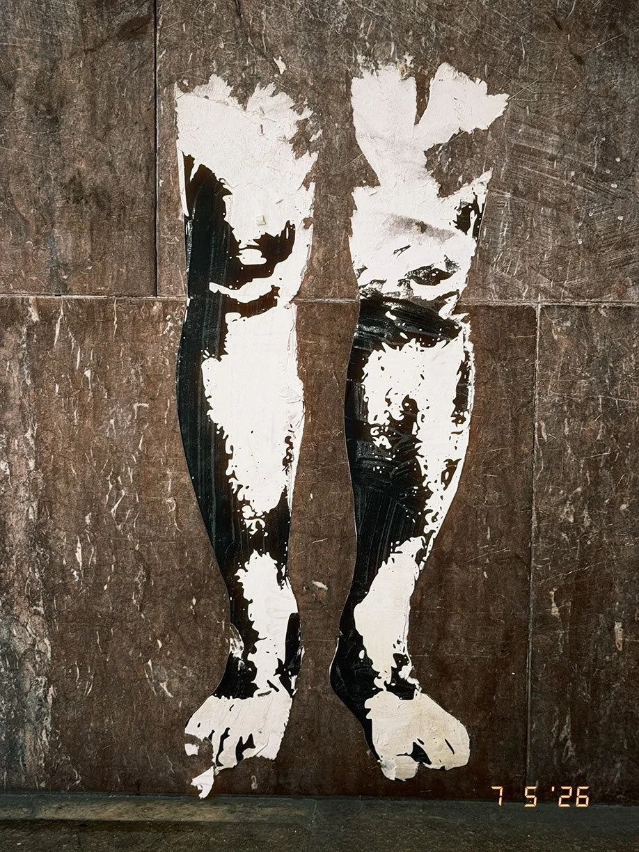 Street art mural of a black and white stylized dog painted on a brown textured wall.