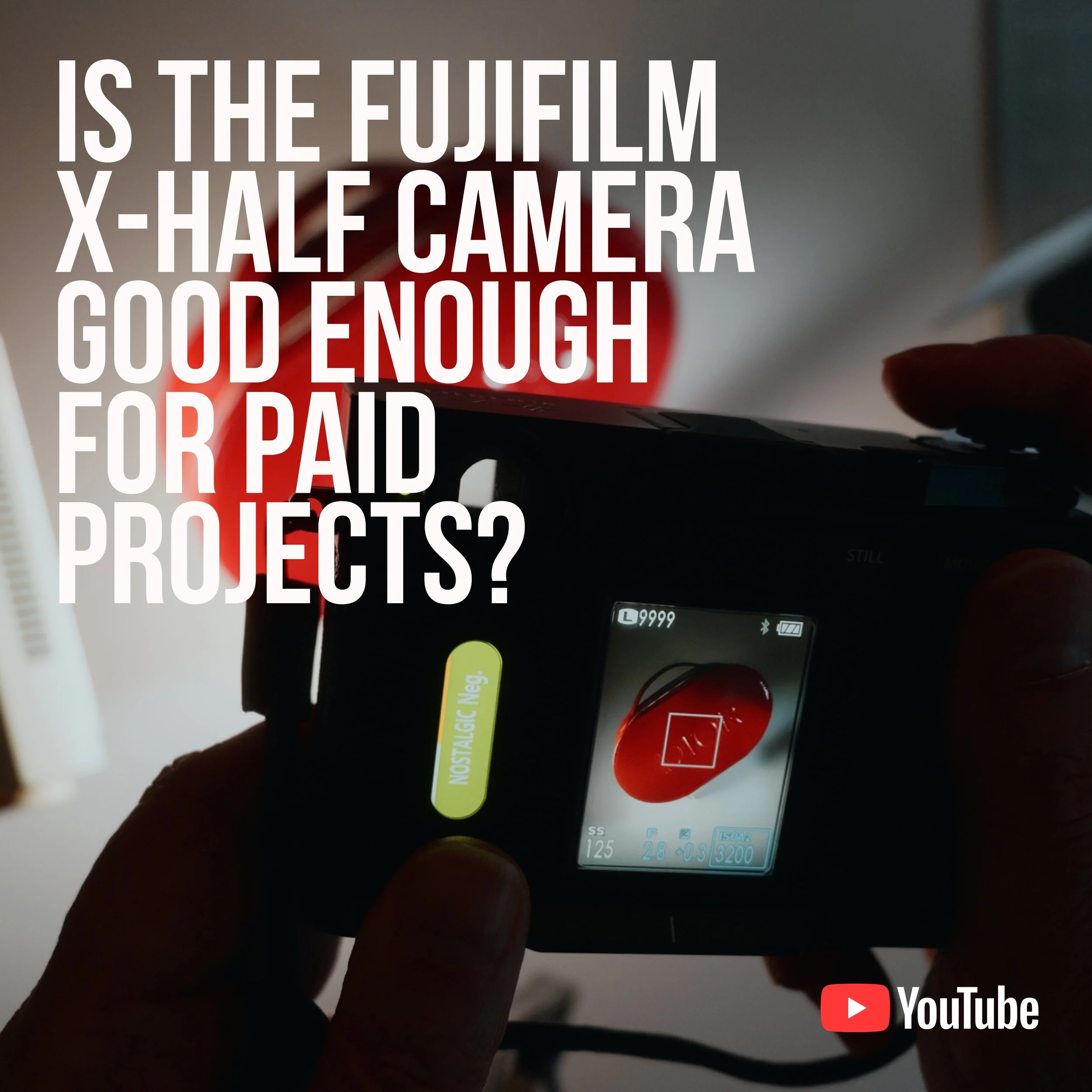 A person holding a Fujifilm camera displaying a red camera on its screen, with overlaid text asking if the Fujifilm X-Half Camera is good enough for paid projects, and a YouTube logo in the bottom right corner.