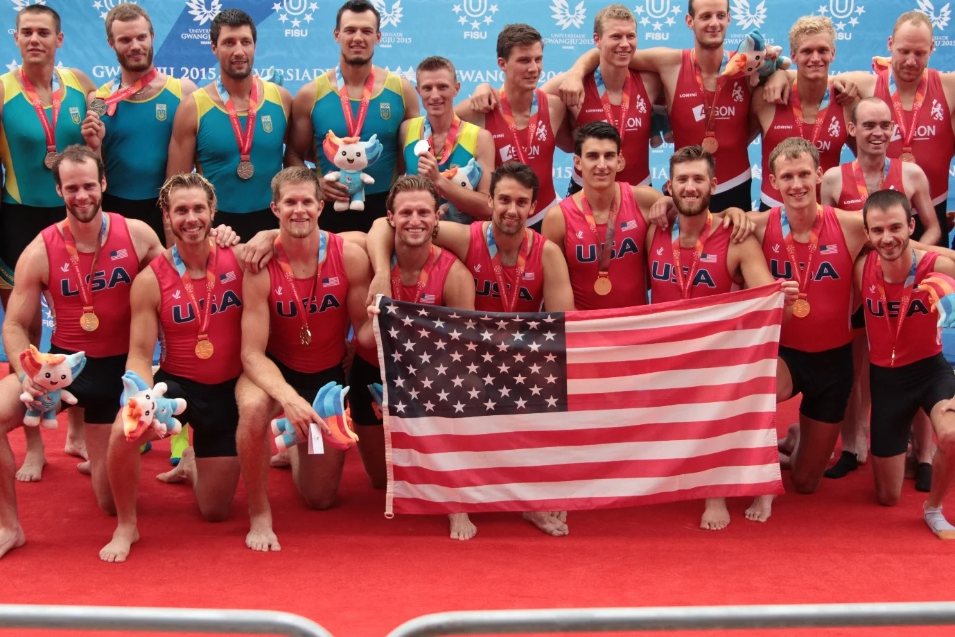 Alumni Matthew Herbers (bottom row, furthest left), Mitchell Tyson (second from left), Wes Vear (fourth from left), and Alex Brown (second from right) winning gold at the 2015 World University Games for the USA in South Korea.