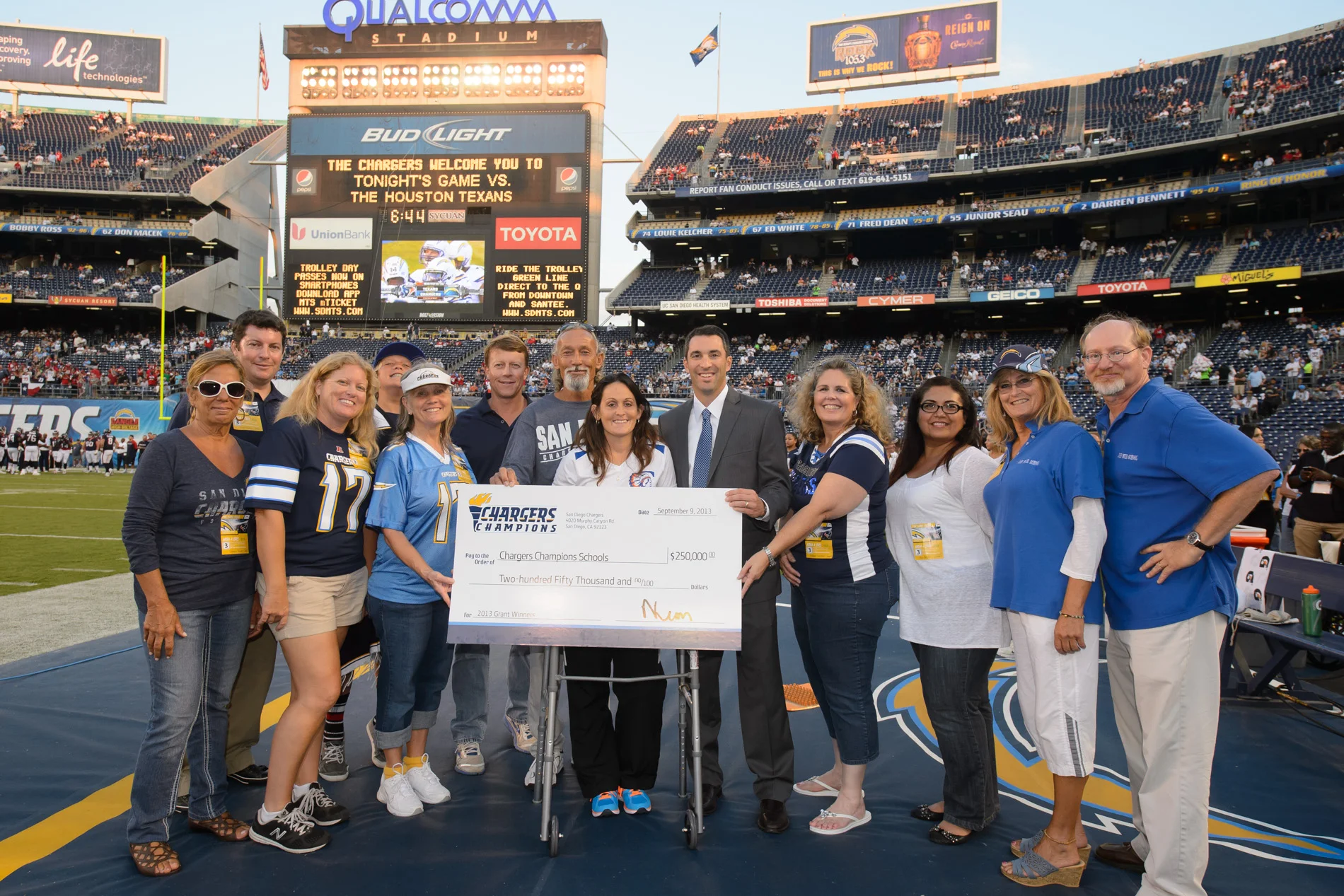 Chargers Champions School Grant Program. Coach Stevens and Coach Maroni from John Muir are on the right in blue.