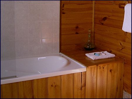 The private ensuite bathroom features a full bath with shower. Self contained bush cabin accommodation at Cradle Mountain Highlanders Cottages in Tasmania Australia with the comforts of home.