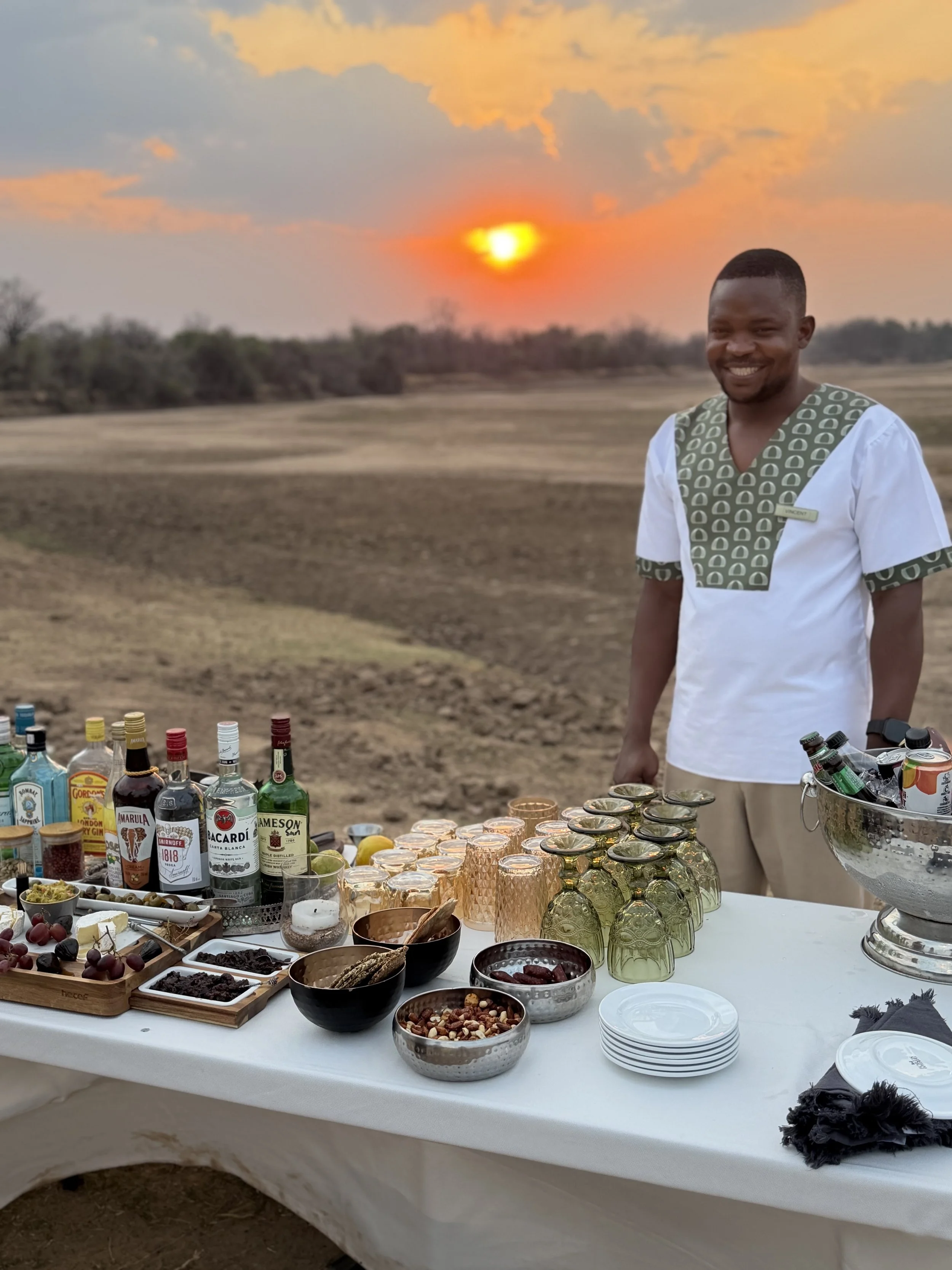 Safari sundowner setup with drinks and snacks at sunset in Africa